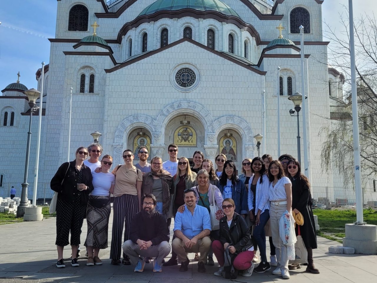 a group of students posing in front of a church in the Balkans